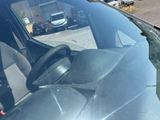 a car that is parked in a lot with a truck in the background