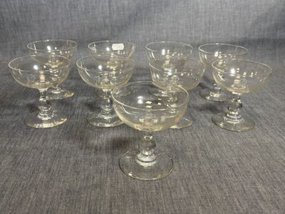 six glass goblets are lined up in a row on a table