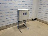 une photo d'une machine dans une pièce, avec une affiche accrochée au mur derrière elle