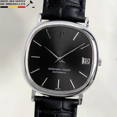 un gros plan d'une montre avec un bracelet en cuir noir