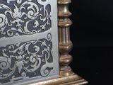 a silver clock sitting on top of a black table