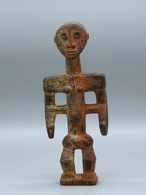 an old wooden figurine of a man holding a shield