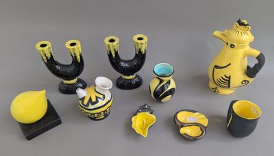 des vases jaunes et noirs ainsi que d'autres objets décoratifs posés sur une surface grise