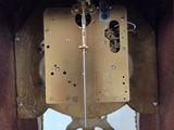 a wooden clock with a metal face and a clock face on it