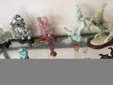 de nombreuses figurines en verre posées sur une étagère en verre