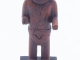 figurine représentant un homme debout sur un socle noir, sur fond blanc
