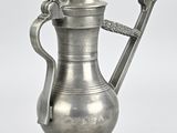 a silver coffee pot with a handle on a white background