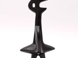 black sculpture of a man with a hat on a white background