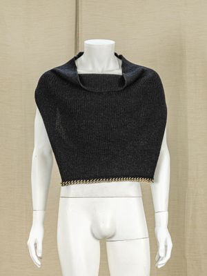 a mannequin wearing a black top with a chain around the neck