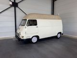 a white van parked in a garage with a tan cover on the roof