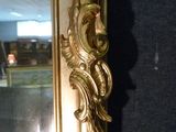 a mirror with a gold frame and a mirror with a bird on it