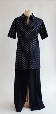 Le mannequin porte une chemise et un pantalon à pois noirs et blancs.