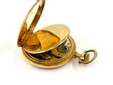 a gold pocket watch on a white surface