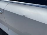 the door handle of a white car with a sticker on the side of it