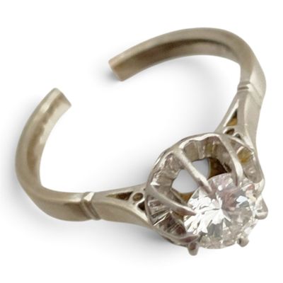 une bague sertie d'un diamant, sur fond blanc