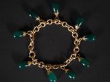 un bracelet en or orné de perles de verre vertes sur fond noir
