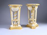 une paire de vases dorés et blancs posés sur une table blanche