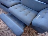 a blue couch that is sitting on a carpet