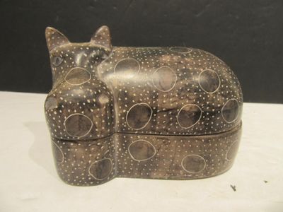 a cat sitting on top of a box on a table
