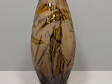a glass vase with a brown and black design on it
