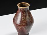a brown vase sitting on a white table with a black background