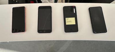 quatre téléphones portables posés les uns à côté des autres sur une table