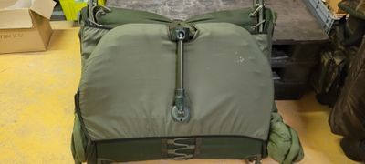 a green bag with a zipper on it sitting on the floor