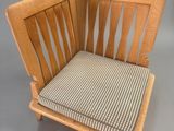 an image of a wooden chair with a striped seat cushion
