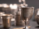 silver cups and spoons sitting on a table