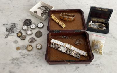 une boîte en bois sur laquelle sont posés une montre, un bracelet et d'autres objets