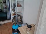 une pièce avec une table et une étagère sur laquelle se trouve une bouilloire