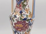 a vase with a floral design on it sitting on a table