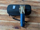 a black case with a blue handle on a wooden floor