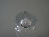 a glass with a small object in it sitting on a table
