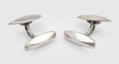 une paire de boutons de manchette en argent sur fond blanc