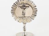 a silver plate with a cross on it on a stand