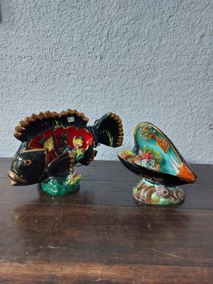 two fish figurines sitting on a table next to each other