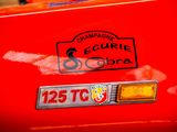 a close up of a red car with a badge on it