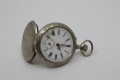 a silver pocket watch with roman numerals on it