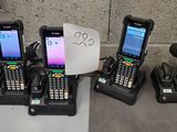 Plusieurs téléphones portables sont alignés sur une table à côté d'un panneau