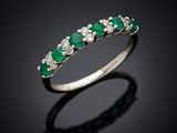 une bague en émeraude et diamant sur une surface noire