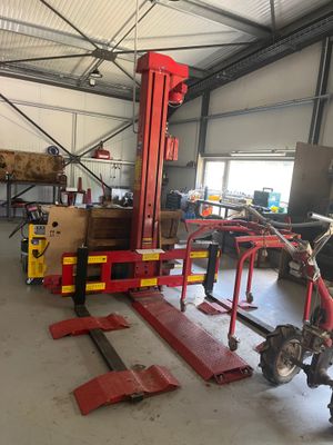 une photo d'un homme en train de travailler sur un véhicule dans un garage