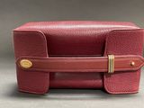 the red leather case has a gold buckle on it