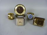 cinq types différents d'horloges et de montres-bracelets posés sur une table