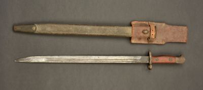 an old knife and a small knife on a table