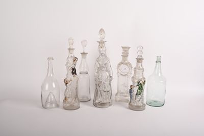 de nombreuses bouteilles en verre alignées sur une surface blanche