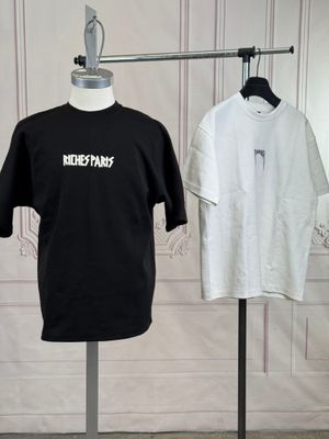 deux t-shirts suspendus à un portant dans une pièce