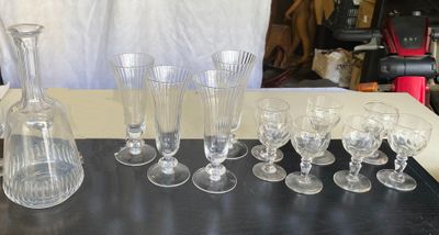 de nombreux verres à vin et une carafe posés sur une table