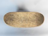a small brown plate with a handle on a white surface