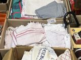 de nombreux cartons contenant des vêtements et d'autres objets, posés par terre